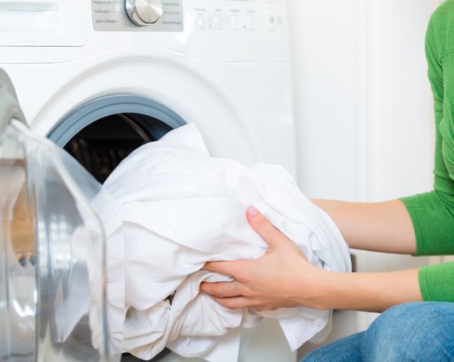 Woman putting laundry in the dryer